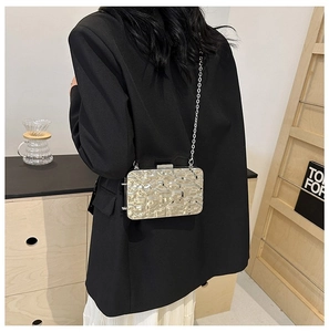 Chic metallic box clutch with water ripple texture worn as a crossbody with chain