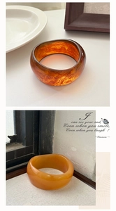 Detailed view of thick resin bangles in amber brown marble and ginger yellow cloudy patterns