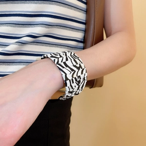 Detail of zebra pattern wide modular cuff bracelet styled on a female model's wrist