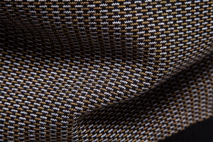 Vue macro du tissu en maille jacquard haute densité avec motif ondulé tricolore et texture épaisse