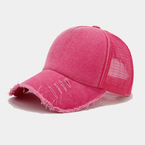 Dettaglio del cappello trucker rosa lavato con retro a rete ed effetto vintage consumato