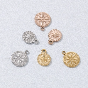 Detail of star pattern round metal pendants in gold, silver and rose gold finishes
