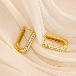 Macro detail of 18K gold-plated U-shaped earrings featuring rows of sparkling rhinestones