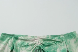 Detail of ruched off-shoulder neckline with green and white marble tie-dye pattern