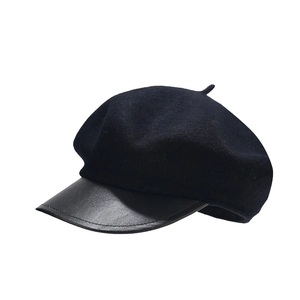 Classic black beret with thick wool top and leather peak brim on white background