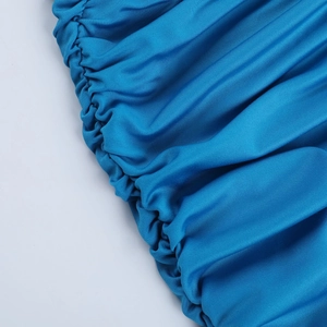 Détail macro du tissu en maille bleu vif avec fronces élastiques sur une robe moulante