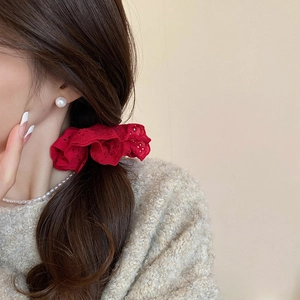 Detail of red hollow lace double-layer scrunchie worn on ponytail by a model