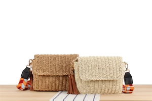 Detail of hand-woven straw bags with geometric shoulder straps and tassel charms