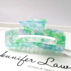 Detailed side view of large rectangular hair claw clip with blue and green marble texture