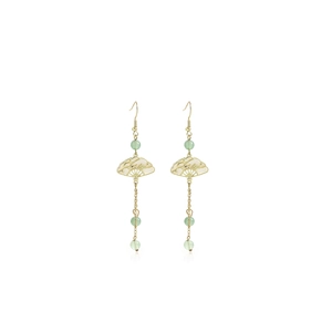 Detail of gold fan-shaped earrings with light green beads and elegant long tassels