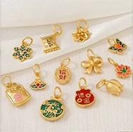 Flat lay of 12 gold charms with colorful enamel floral and lucky lock designs