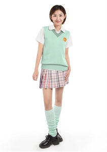 Detail of green knit leg warmers styled with a JK uniform and plaid pleated skirt