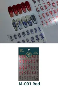 Macro detail of laser red rose nail stickers and 3D metallic floral decals on packaging