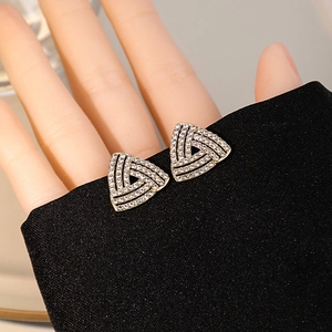 Macro detail of gold-plated triangle earrings with pavé-set sparkling cubic zirconia