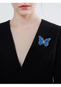 Detailed view of luxury blue butterfly brooch with zircons pinned on a black suit jacket