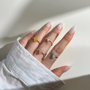 Detailed view of pear cut yellow pink and white gemstones set in gold and silver bands