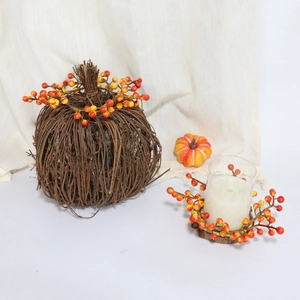 Macro shot of Halloween orange berry candle ring with woven pumpkin decor on tabletop