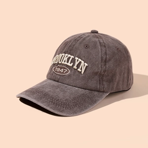 Close-up detail of white Brooklyn 1947 embroidery on vintage brown washed baseball cap