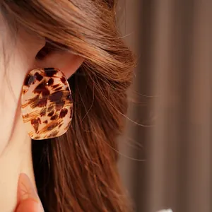 Minimalist square leopard print earrings with vintage tortoiseshell texture on female model