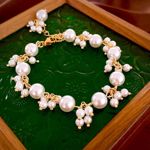Detailed close-up of French vintage pearl bracelet with golden links on a glass tray