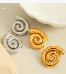 Détails macro de boucles d'oreilles spirales torsadées en or 18 carats et argent poli