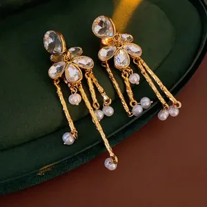Vintage gold pearl tassel earrings with crystal flower charms on green velvet box