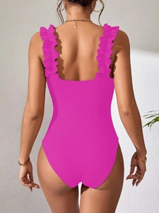 Detail of rose red ribbed knit bodysuit showing ruffled straps and open back design