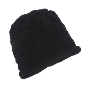 Detail of black crochet knit beanie with 3D floral patterns and rolled edge texture