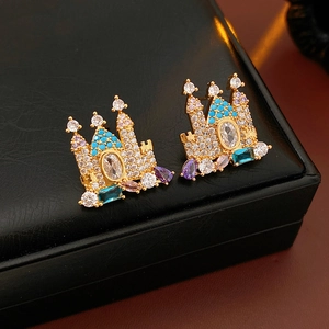 Detail showing gold-plated castle earrings with zircon stones and blue crystal accents