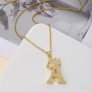 Macro detail of gold crown initial A pendant necklace with pavé cubic zirconia inlay