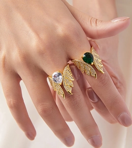 Detail of copper angel wing ring with pear-cut emerald zircon and paved diamonds
