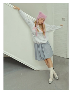 Detail of pink plush cat ear beanie with strawberry star motif on a female model