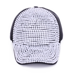 Detail shot of black cotton baseball cap with intricate white rhinestone and bead patterns