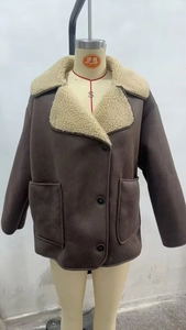 Detail of brown suede jacket with shearling collar, large pockets, and black buttons