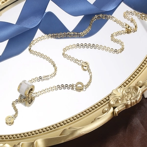 Luxurious gold titanium necklace with cat-eye cylinder pendant and crystal accents