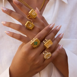 Set of five gold titanium steel rings with clover and star motifs on model hands
