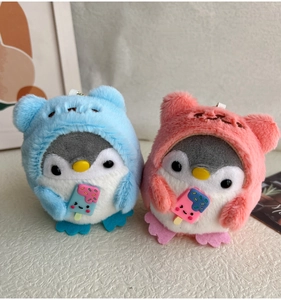 Close-up of pink and blue penguin plush keychains holding miniature ice creams