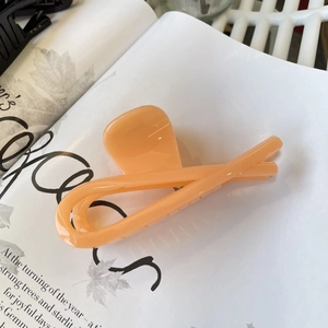 Detail of a large apricot hair claw clip on a stylish magazine background