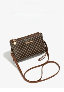 Close-up of vintage brown crossbody bag with gold dot pattern and metallic zipper detail