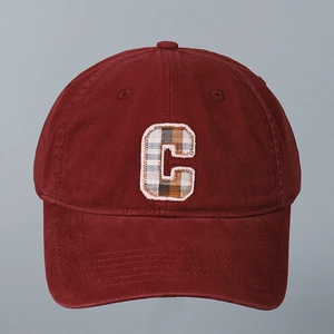 Close-up of letter C embroidery with plaid pattern on a dark red cotton baseball cap