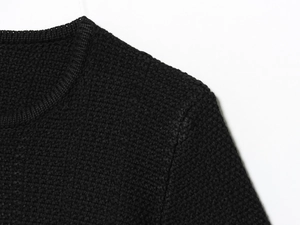 Close-up of the round neckline and fine knit texture of this black button cardigan