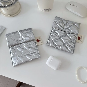 Close-up of metallic silver quilted small pouches with heart patterns and snap closures