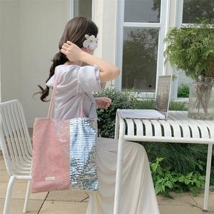 Detail of pink and silver sequin velvet tote bag in a stylish outdoor setting