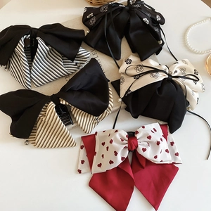 Gros plan de barrettes à nœuds en tissu aux motifs variés sur un décor vintage élégant