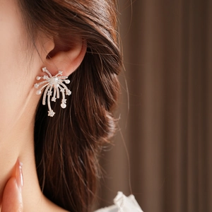 Close-up of 18K gold plated fireworks earrings with pearls and crystals on a model