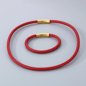 Détail du collier et bracelet en cuir tressé rouge avec fermoir magnétique doré