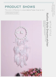 Detail of white dream catcher featuring daisy flower accents and hanging soft feathers