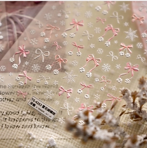 Detailed 5D embossed nail stickers featuring pink bows and white snowflakes for winter