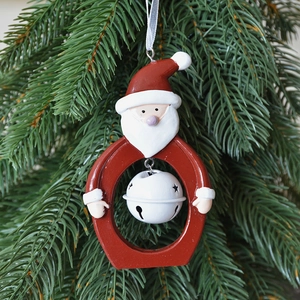 Hollow Santa resin Christmas bell ornament with metal star cutouts on green pine background
