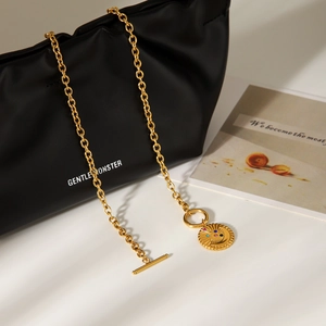 Collier en acier doré avec pendentif lune étoile et fermoir OT sur pochette en cuir